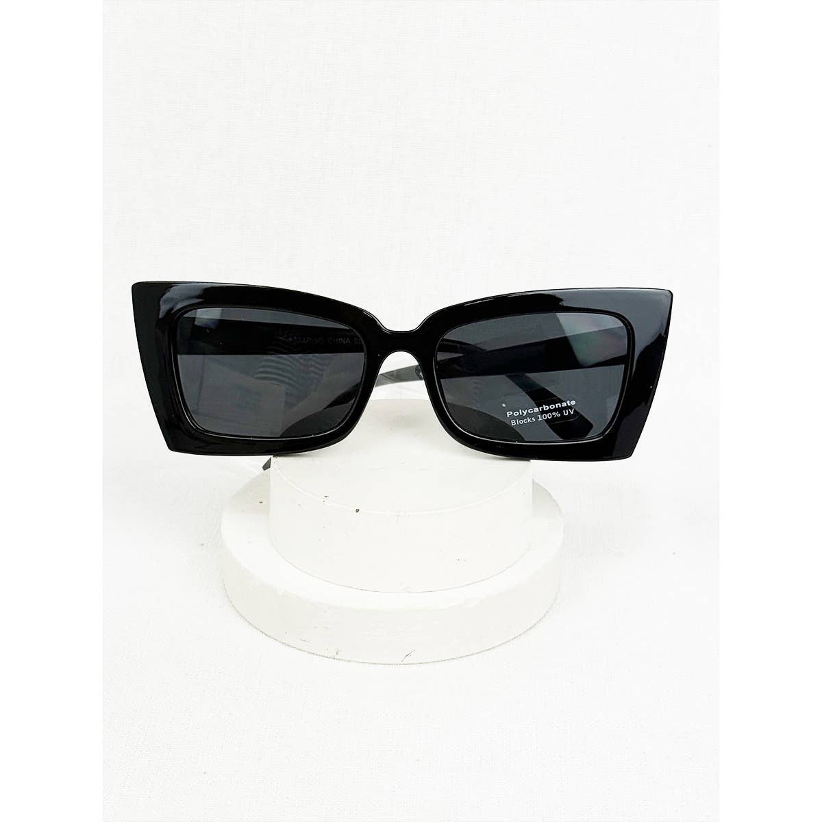 Black sunglasses on a white stand with a white background