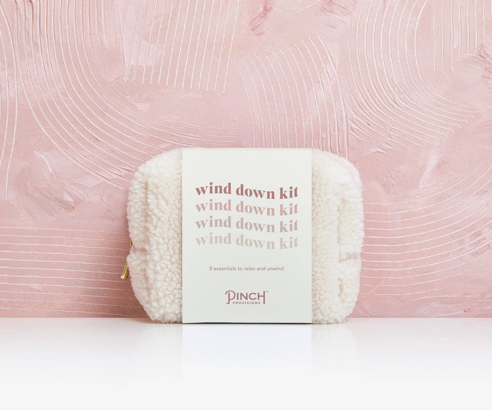 Wind down kit with yarn on a pink textured background