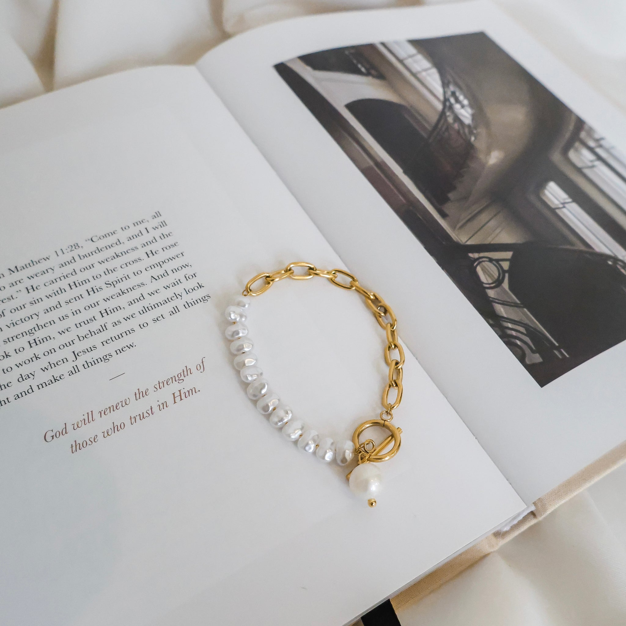 Bracelet with pearls and gold chain on an open book