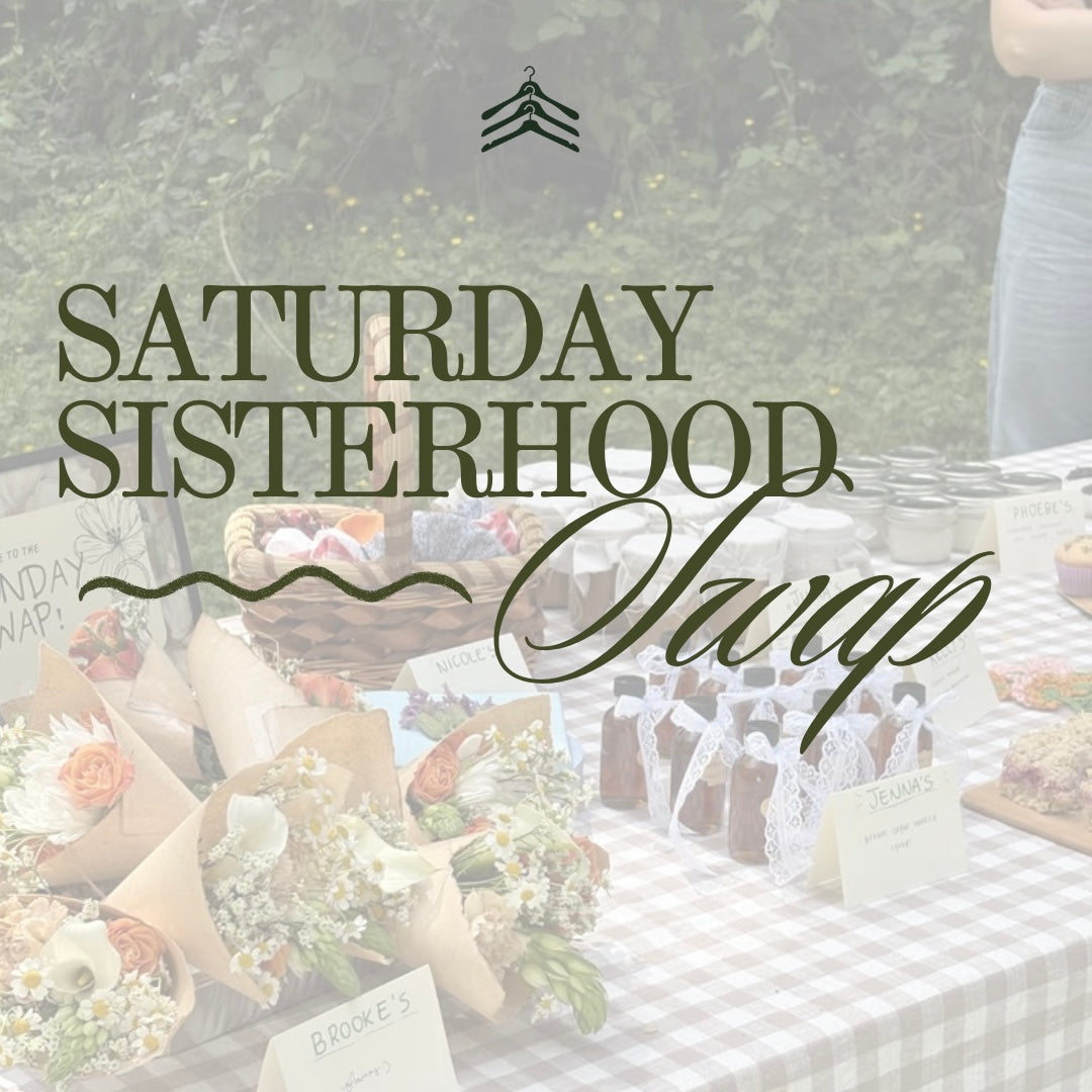 Promotional graphic for 'Saturday Sisterhood Swap' featuring a blurred outdoor table setup with flowers, bottles, and small products, overlaid with the event title in dark green text.
