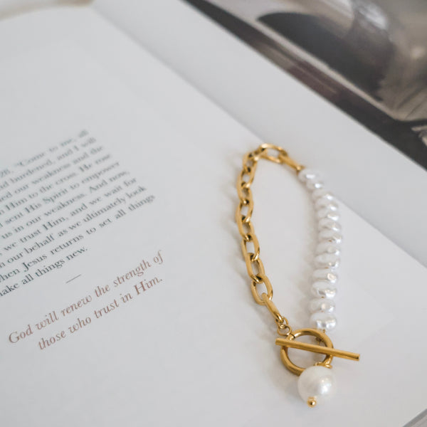 Pearl and gold bracelet on an open book