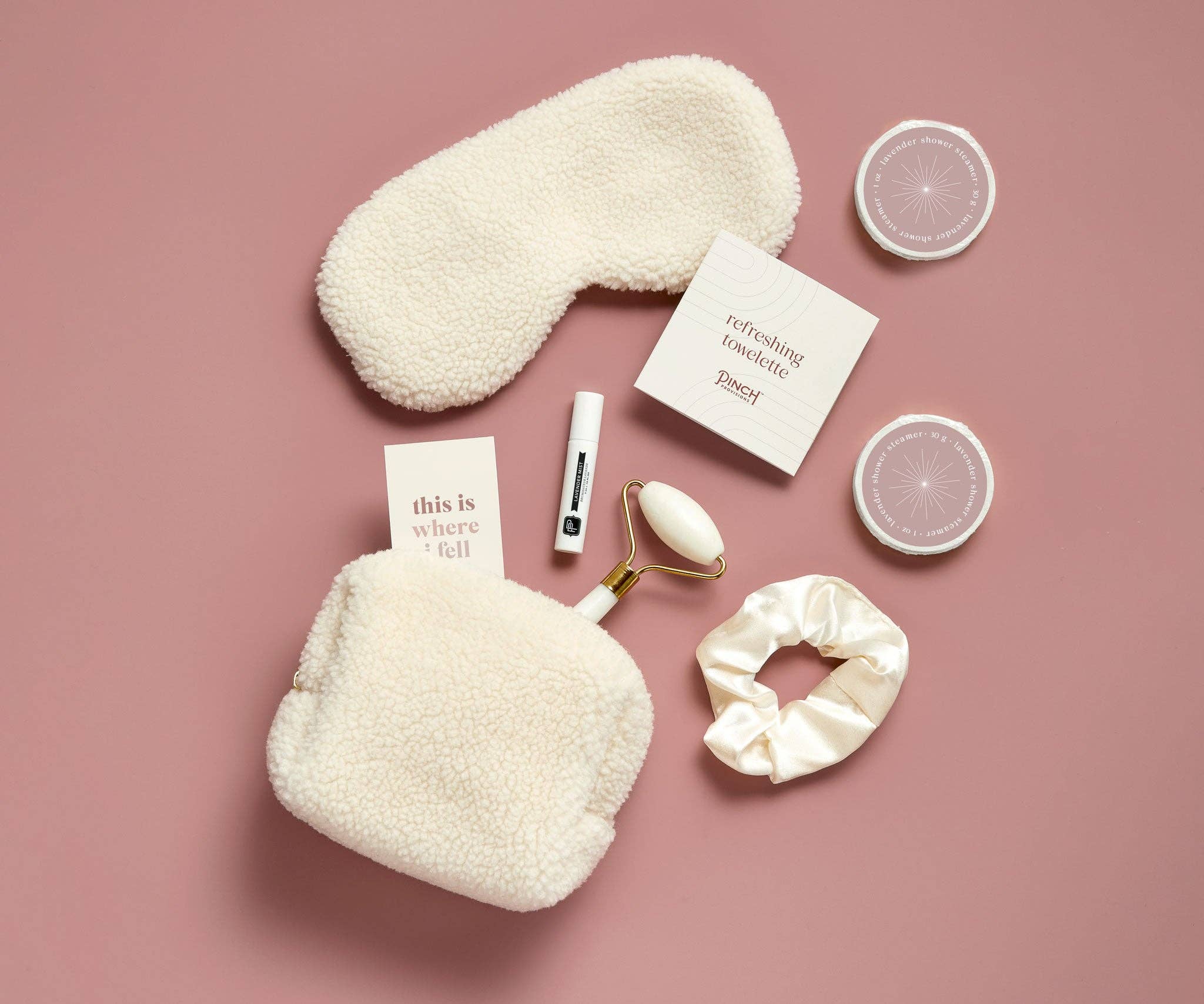 Set of beauty products including a sleep mask, eye masks, and skincare items on a pink background