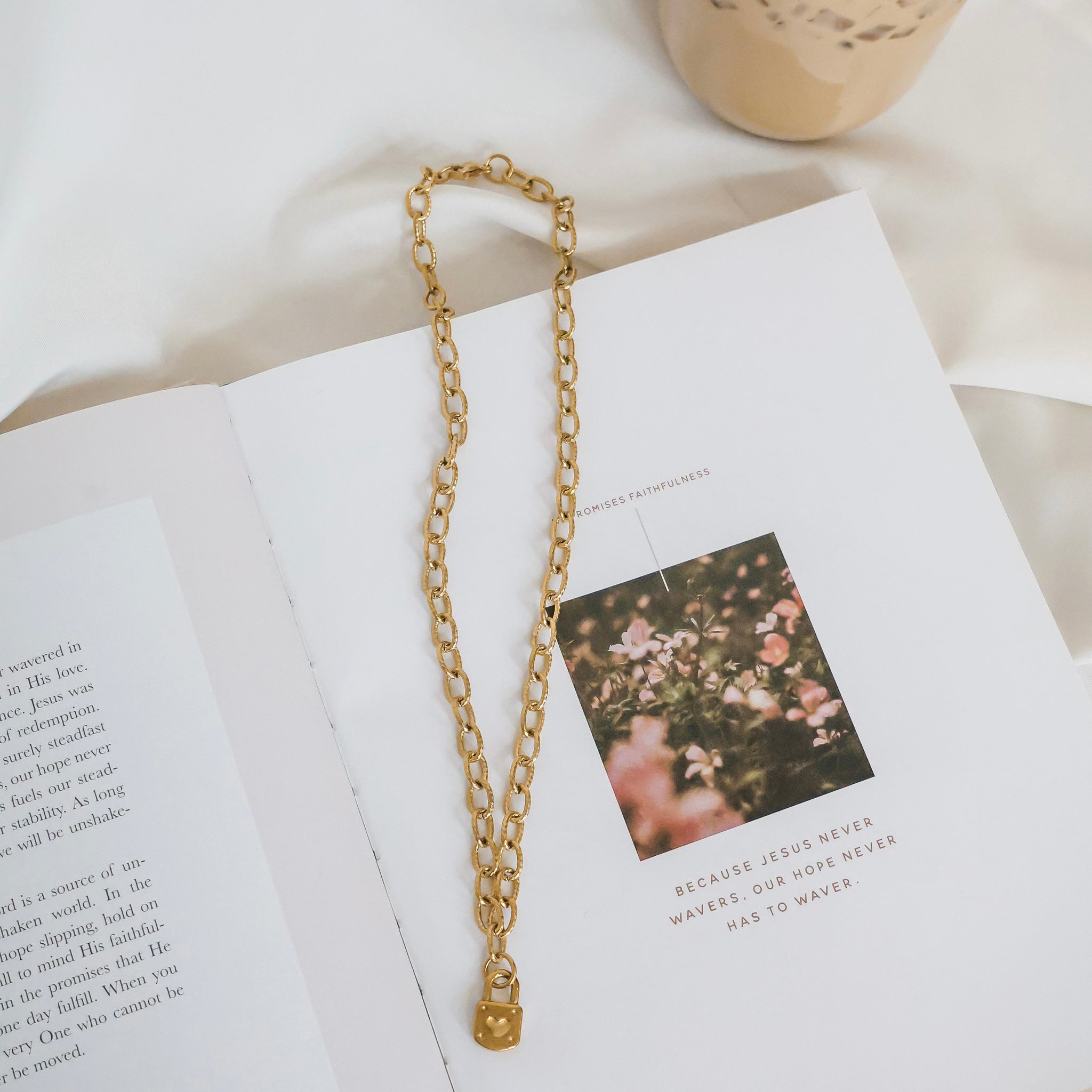 Gold chain necklace on an open book with a floral photo