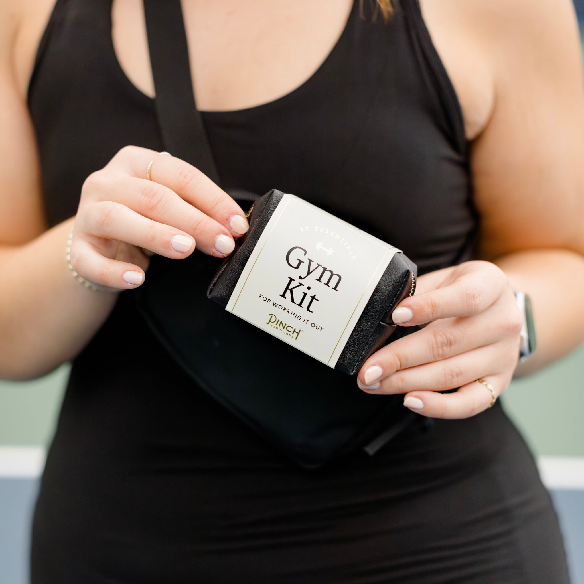 Woman holding a black "Gym Kit"