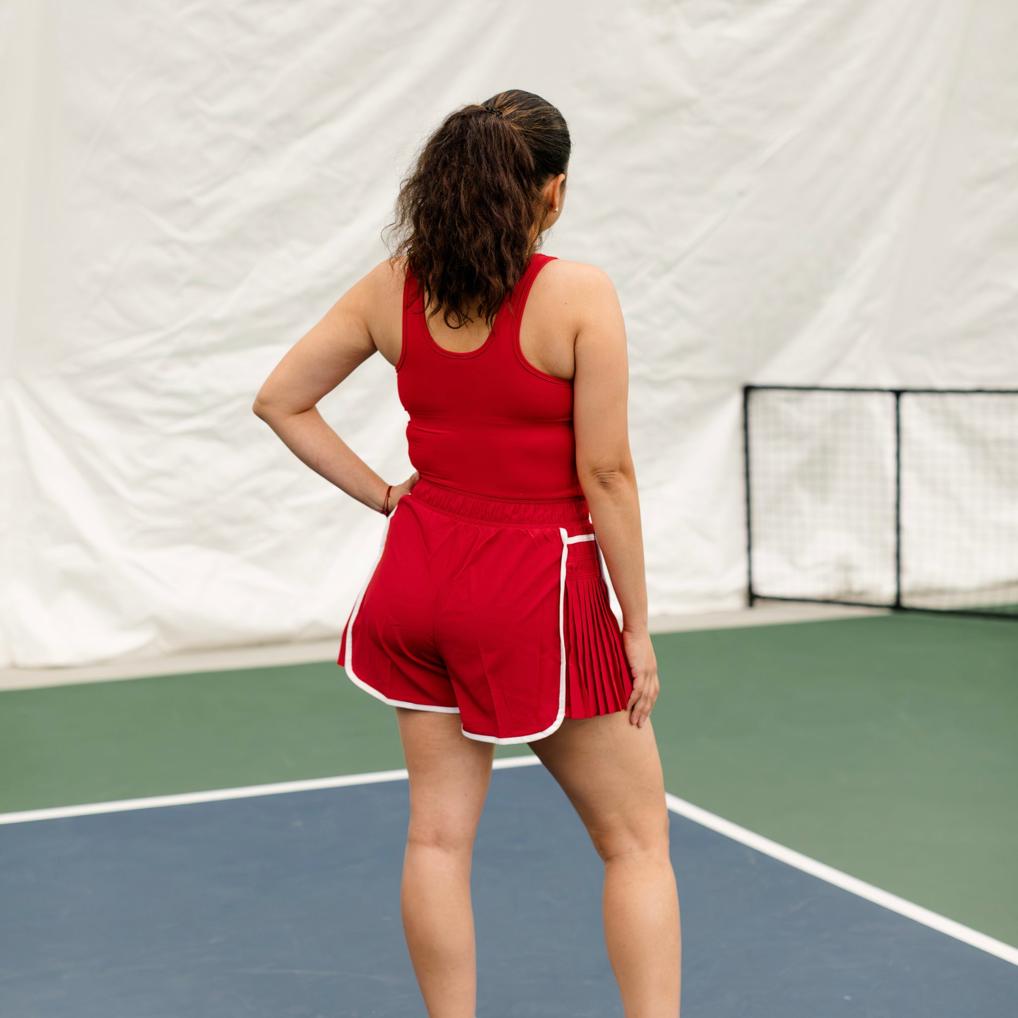 Woman wearing a red and white shortsie showing the back side. 