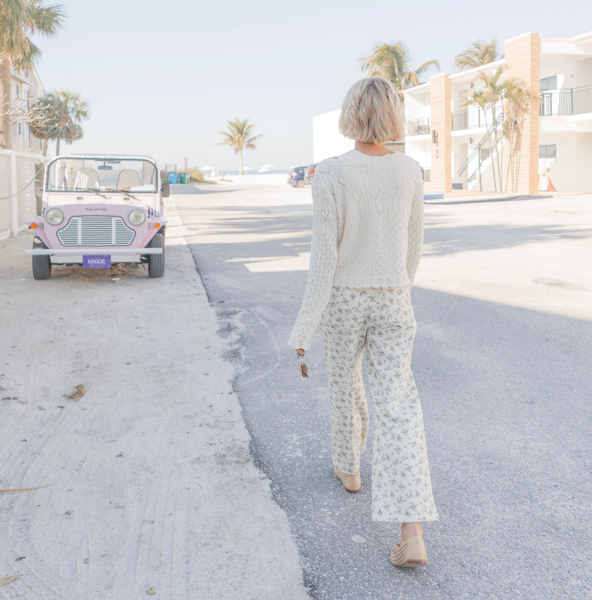 Woman walking on a street with a small vehicle in the background