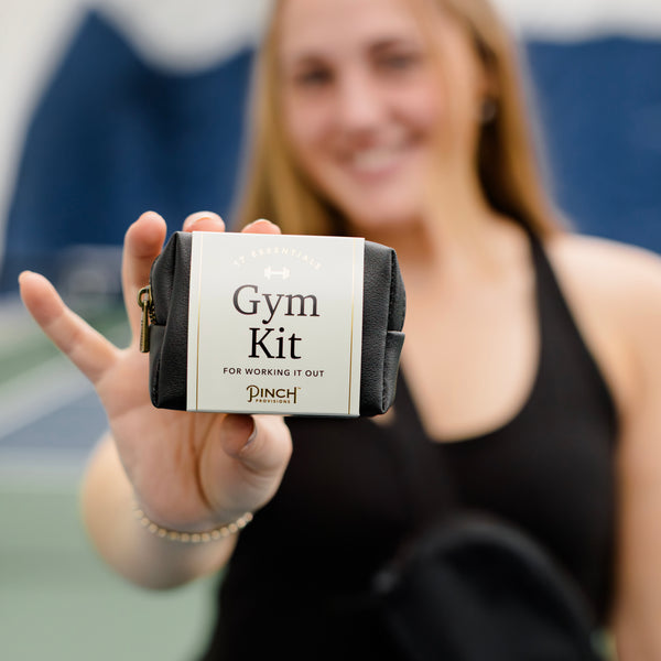 Woman holding a black "Gym Kit" in one hand.