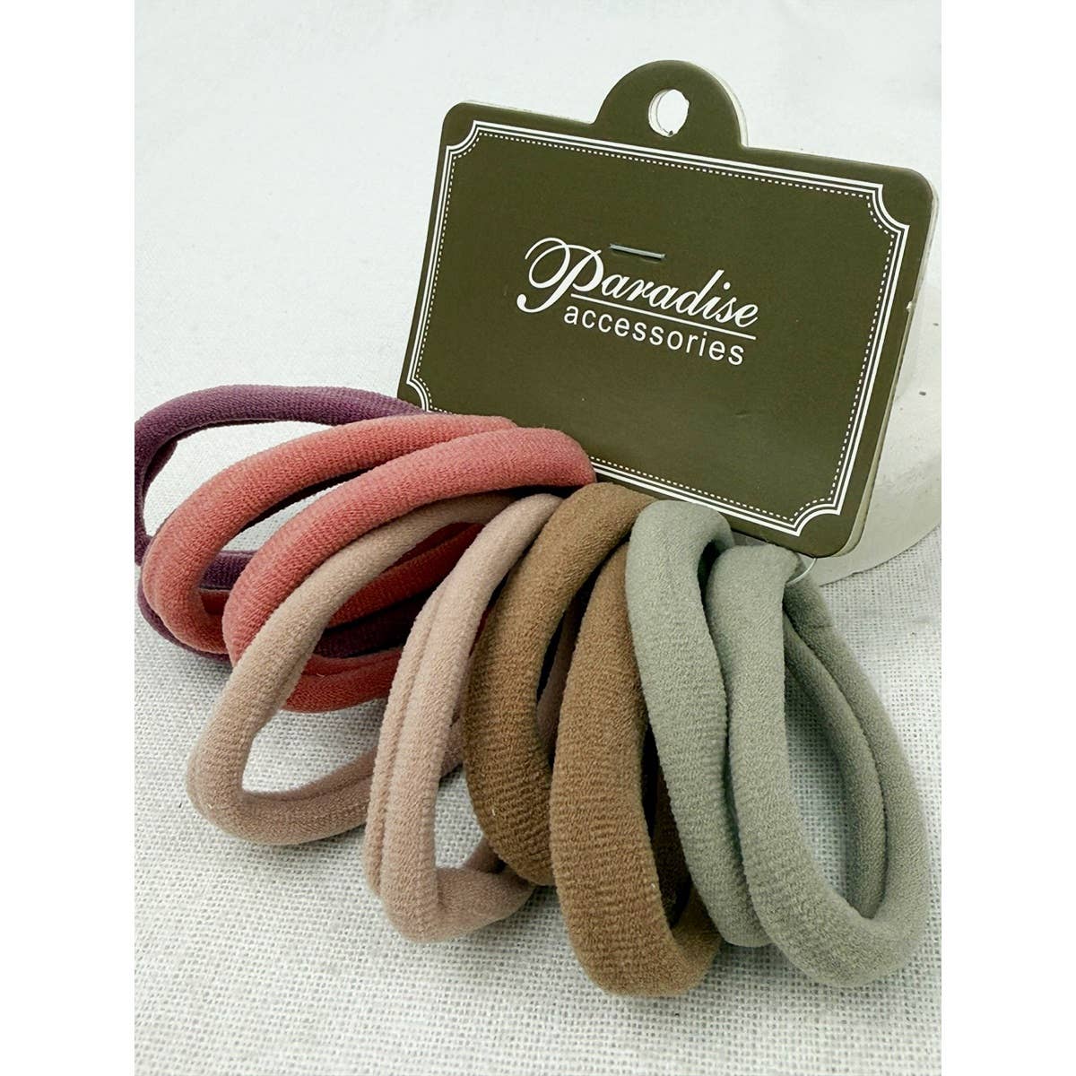 Set of colorful hair ties with a 'Paradise Accessories' label on a light background