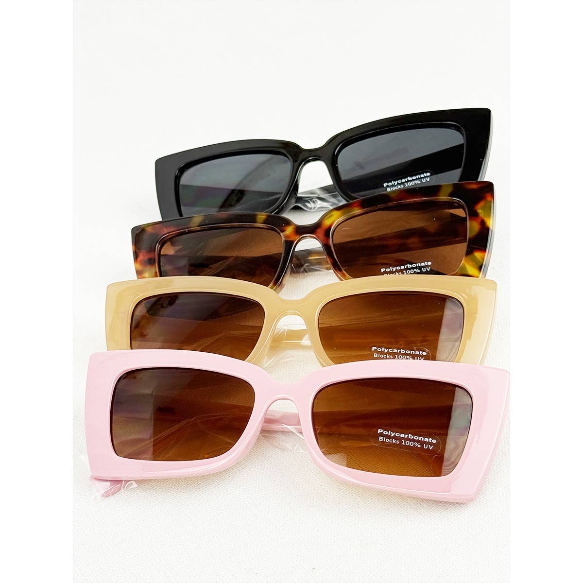 Four pairs of sunglasses with different frames and lenses on a white background